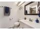 Bathroom featuring a white vanity, toilet, towel hooks, and modern fixtures and clean lines at 6366 Nassau Ct, Highlands Ranch, CO 80130