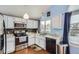 Modern kitchen with stainless steel appliances, white cabinets, and granite countertops at 6366 Nassau Ct, Highlands Ranch, CO 80130