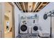 Basement laundry room with open-beam ceiling, shelving, and modern washer and dryer units at 6366 Nassau Ct, Highlands Ranch, CO 80130