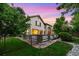 Well-maintained backyard with stone accents, lush lawn, and mature trees in a serene setting at 6427 S Tibet St, Aurora, CO 80016