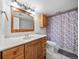 Bathroom with wood vanity, white countertop, large mirror, and patterned shower curtain at 6427 S Tibet St, Aurora, CO 80016