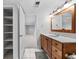Bathroom features wood vanity, modern fixtures, and tile flooring with access to basement at 6427 S Tibet St, Aurora, CO 80016