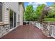 Spacious deck with stone accents offers ample outdoor seating space with lush, mature landscaping at 6427 S Tibet St, Aurora, CO 80016