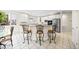 Open concept kitchen with a breakfast bar, stainless steel appliances and white cabinetry at 6427 S Tibet St, Aurora, CO 80016
