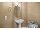 Elegant powder room with pedestal sink, decorative mirror, and stylish fixtures at 6427 S Tibet St, Aurora, CO 80016