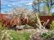 Secluded back yard featuring mature flowering trees, mature shrubs and a small stone bench at 6640 Grove St, Denver, CO 80221