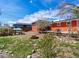 Spacious backyard with green grass, a cozy fire pit, mature trees, and a patio, great for outdoor entertaining at 6640 Grove St, Denver, CO 80221