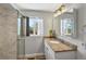 Bright bathroom with marble shower, granite countertop, modern vanity, and large window at 6640 Grove St, Denver, CO 80221