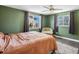 Well-lit bedroom features two windows, cozy chair, ceiling fan, and soft carpet at 6640 Grove St, Denver, CO 80221