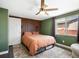 Charming bedroom features a slatted accent wall, ceiling fan, and plush area rug with a large window letting in ample light at 6640 Grove St, Denver, CO 80221