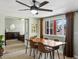Bright dining area with wood floors, a modern ceiling fan, and large windows offering natural light and neighborhood views at 6640 Grove St, Denver, CO 80221