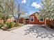 Charming single-story home with a brick-red exterior and a long paved driveway at 6640 Grove St, Denver, CO 80221