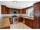 Modern kitchen boasts stainless steel appliances, granite countertops, and ample storage with rich wooden cabinets at 6640 Grove St, Denver, CO 80221