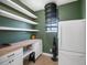 Pantry area with white shelving, butcher block countertops, green walls, and stainless steel refrigerator at 6640 Grove St, Denver, CO 80221