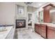 Bright and luxurious bathroom suite with a soaking tub, a fireplace, and a vanity, offering a relaxing retreat at 920 Neon Forest Cir, Longmont, CO 80504