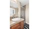 Neutral bathroom with a tiled shower, vanity with sink, and framed mirror at 920 Neon Forest Cir, Longmont, CO 80504