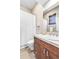 Bright bathroom with a wood vanity, neutral tile, and a white shower curtain and toilet at 920 Neon Forest Cir, Longmont, CO 80504