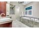 Luxurious bathroom featuring a soaking tub, a marble shower, and a vanity with marble countertops at 920 Neon Forest Cir, Longmont, CO 80504