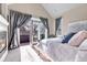 Bedroom with a fireplace and balcony access, enhanced by natural light and elegant curtains at 920 Neon Forest Cir, Longmont, CO 80504