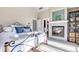 Bright bedroom with fireplace, rod iron bed frame, ensuite, and storage at 920 Neon Forest Cir, Longmont, CO 80504