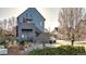 View of the home's unique exterior, with blue siding, a small garden and a detached garage at 920 Neon Forest Cir, Longmont, CO 80504