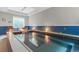 Indoor pool with tile accents, soft lighting, and comfortable seating creates a tranquil and private oasis at 920 Neon Forest Cir, Longmont, CO 80504