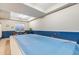 Indoor pool with a blue cover, surrounded by blue tile accents and neutral decor at 920 Neon Forest Cir, Longmont, CO 80504