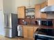 A functional kitchen featuring stainless steel appliances, light wood cabinets, and a tile backsplash at 920 Neon Forest Cir, Longmont, CO 80504