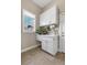Functional laundry room featuring ample storage, a utility sink, and a bright window at 920 Neon Forest Cir, Longmont, CO 80504
