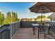 Relaxing outdoor patio with table and chairs offering scenic views and a shaded umbrella at 920 Neon Forest Cir, Longmont, CO 80504