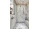 Elegant walk-in shower with marble tiling, a rain shower head, and a built-in bench, creating a spa-like experience at 920 Neon Forest Cir, Longmont, CO 80504