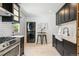 Modern kitchen with stainless steel appliances, farmhouse sink, dark cabinets, and a convenient washer and dryer at 3625 W 9Th Ave, Denver, CO 80204