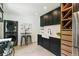 Bright kitchen featuring stainless appliances, dark cabinets, wine rack, white countertop and a washer and dryer at 3625 W 9Th Ave, Denver, CO 80204