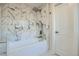 Bathroom with large tub and shower featuring marble tile and modern fixtures at 4385 Carr St, Wheat Ridge, CO 80033