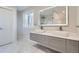 Modern bathroom with double vanity, sleek fixtures, and a view into the marble tiled shower at 4385 Carr St, Wheat Ridge, CO 80033