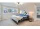 Bright bedroom with a large window, bed, side tables with lamps, and unique artwork at 4385 Carr St, Wheat Ridge, CO 80033