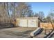 Two car garage with large driveway and wood-accented landscaping at 4385 Carr St, Wheat Ridge, CO 80033