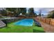 Outdoor pool with astroturf and wood chip landscaping, stone accent wall and privacy fence at 4385 Carr St, Wheat Ridge, CO 80033
