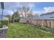 Lush backyard with manicured lawn, garden beds, and a wooden fence at 5455 W 112Th Pl, Westminster, CO 80020