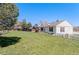 Large grassy backyard with mature trees and partial fencing, great for outdoor activities at 653 S Main St, Elizabeth, CO 80107