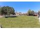 Expansive backyard featuring lush green grass, mature trees and a charming white picket fence at 653 S Main St, Elizabeth, CO 80107