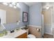 Bathroom with modern fixtures, white toilet and sink, framed art, and earth tone shower at 653 S Main St, Elizabeth, CO 80107