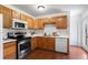 Well-lit kitchen featuring wood cabinets, white countertops, and stainless steel appliances at 653 S Main St, Elizabeth, CO 80107