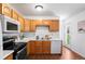 Well-lit kitchen featuring wood cabinets, white countertops, and stainless steel appliances at 653 S Main St, Elizabeth, CO 80107