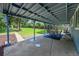 Covered back patio featuring an outdoor dining set and view of the spacious, fenced backyard at 1552 W Caley Ave, Littleton, CO 80120