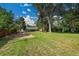 Huge private backyard, framed by mature trees, with back of house and covered patio in view at 1552 W Caley Ave, Littleton, CO 80120