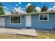 Close up of charming blue single-story home with a well-manicured lawn and a one car garage with walkway at 1552 W Caley Ave, Littleton, CO 80120