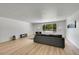Bright living room featuring a plush sofa, contemporary decor, laminate flooring, and large picture window at 1552 W Caley Ave, Littleton, CO 80120