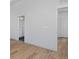 Hallway features light hardwood floors, white walls, and doorway leading to a bathroom at 3109 Bates Ave, Denver, CO 80236