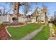 Spacious backyard with a lush lawn, patio, large tree, and a white fence at 3337 Decatur St, Denver, CO 80211